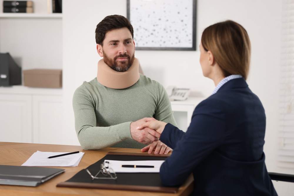 Personal injury lawyer shaking hands with injured client